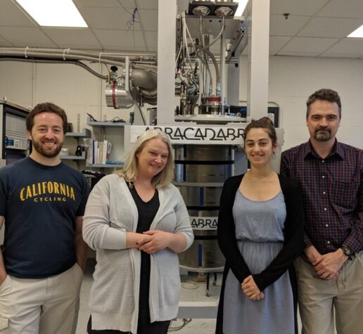 Four team members standing in front of ABRACADABRA, the instrument used to detect axions.