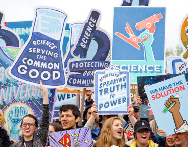 Photo from the March for Science in Washington D.C. showing smiling people holding pro-science signs.