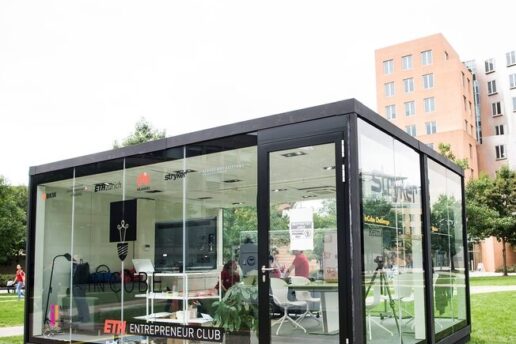 Photo of a glass cube on MIT's North Court that five students were challenged to live and work in.