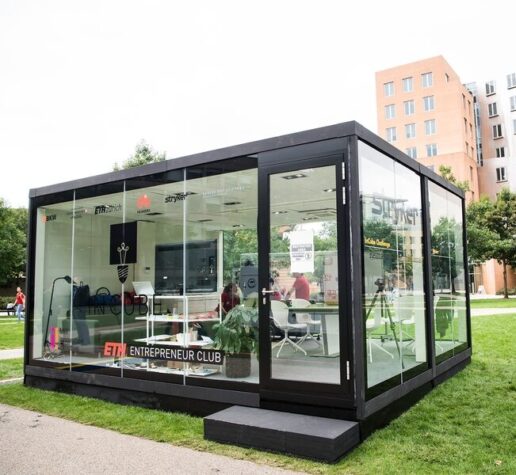 Photo of a glass cube on MIT's North Court that five students were challenged to live and work in.