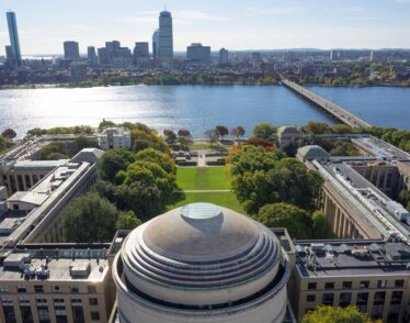Aerial photo of the MIT dome and Killian Court facing the Charles River and Boston.