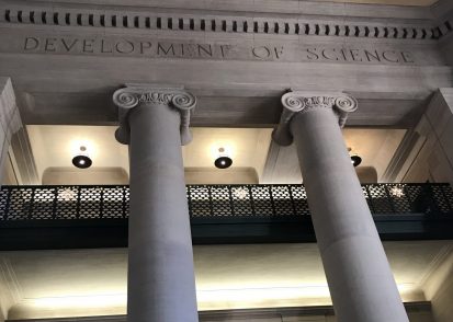 Photo of columns and balconies in MIT Lobby 7 with the etched words