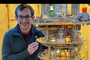 Daniel Rodan-Legrain stands next to a dilution refrigerator