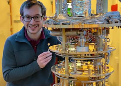 Daniel Rodan-Legrain stands next to a dilution refrigerator