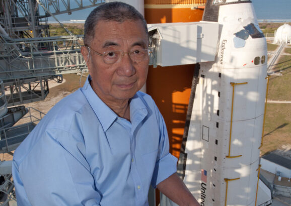 Professor Ting poses in front of the Space Shuttle Endeavor before it launches with AMS-02