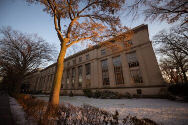 Photo of MIT building with a light cover of snow on the ground