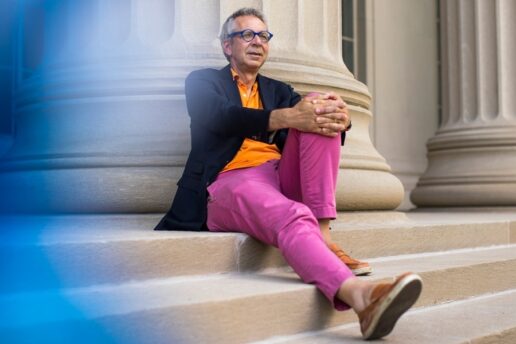 Peter Fisher sits on steps of Building 10