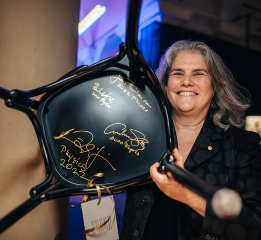 2020 Nobel Laureate and physics alumnae Andrea Ghez '87 poses with signed chair.