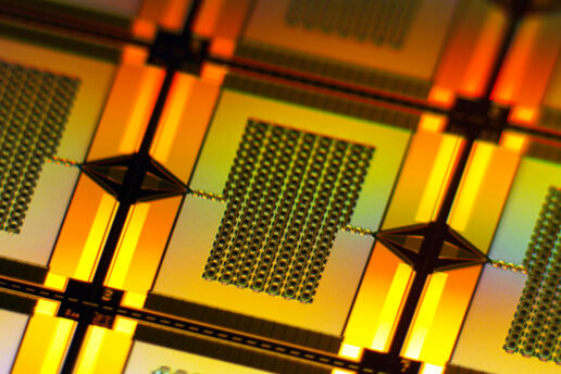 A yellow-lit closeup zooms in on one tiny, rectangular amplifier on the wafer. It has a chain-like rectangular grid in center that connects to the left and right edges of the wafer.