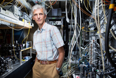 Professor Wolfgang Ketterle stands beside equipment in lab