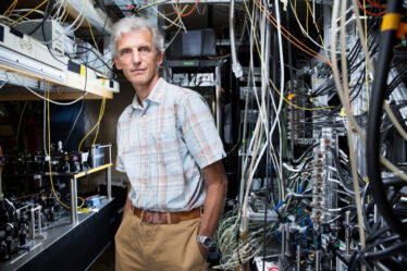 Professor Wolfgang Ketterle stands beside equipment in lab