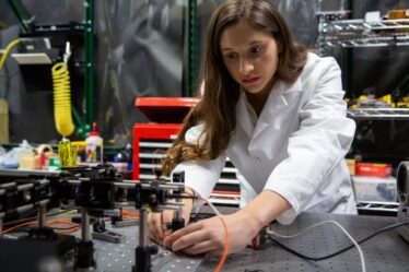 Juliana García-Mejía works in a white lab coat with instruments in lab.