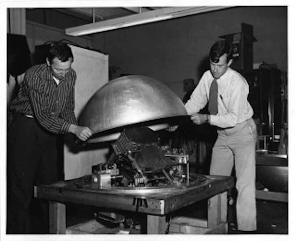 two men lowering cover onto balloon gondola