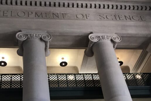 Photo of columns and balconies in MIT Lobby 7 with the etched words 