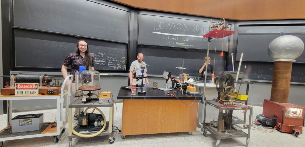 three people stand in classroom surrounded by demo devices