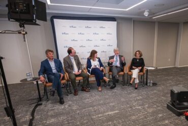 Five people sit before a group discussing Physics, AI and the future of discovery