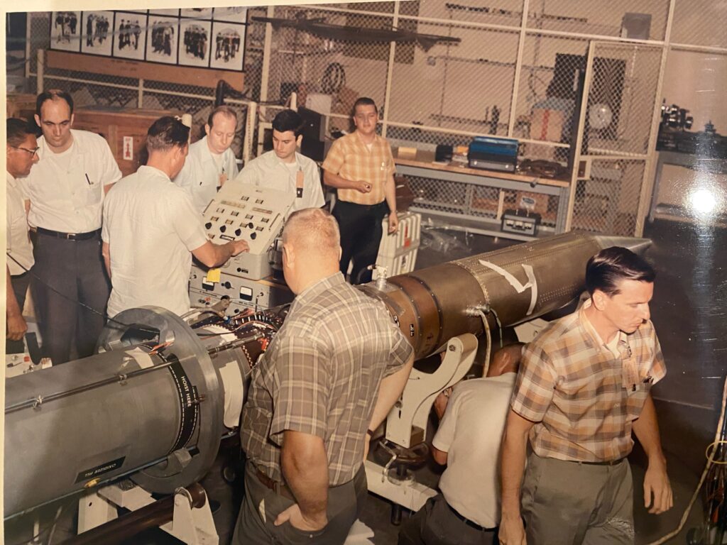 Team of scientists work in lab, preparing a sounding rocket payload for launch.