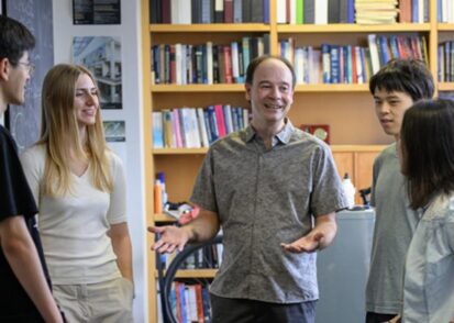 Ian Stewart speaks with a group of four graduate students in his office