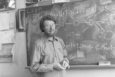 man stands in front of blackboard