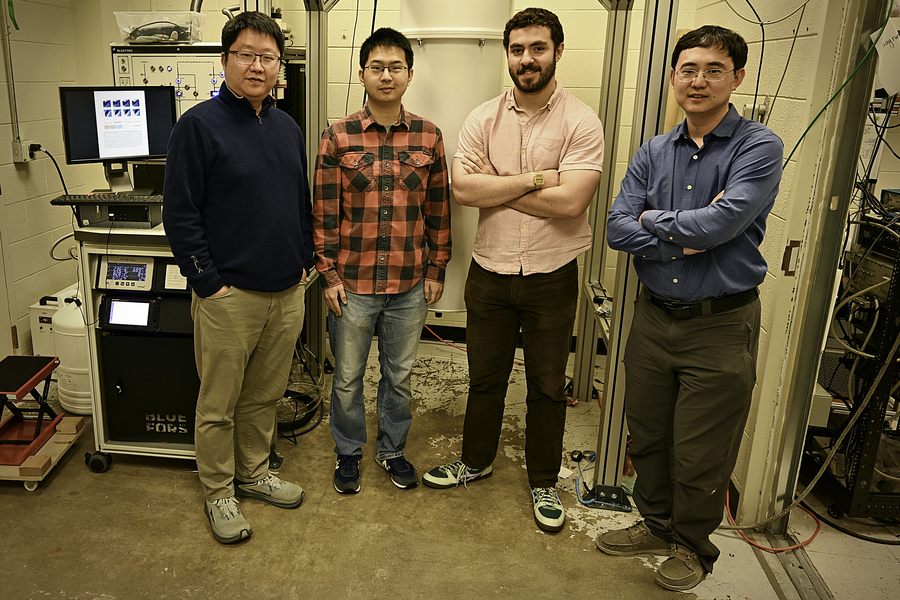 four people pose in lab