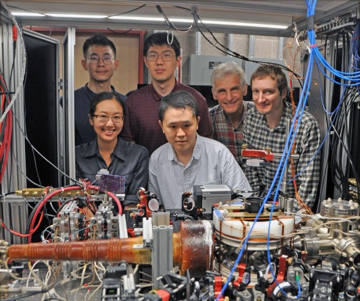 Group photo in the lab in front of a table of devices.