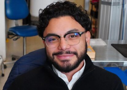 Junior Peña sits in his workspace