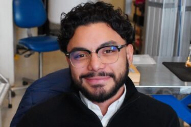 Junior Peña sits in his workspace