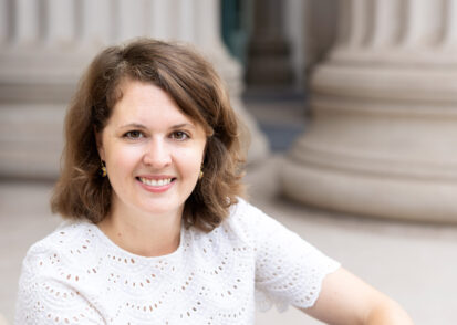woman poses in front of columns