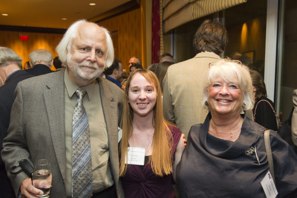 man and two woman pose at event
