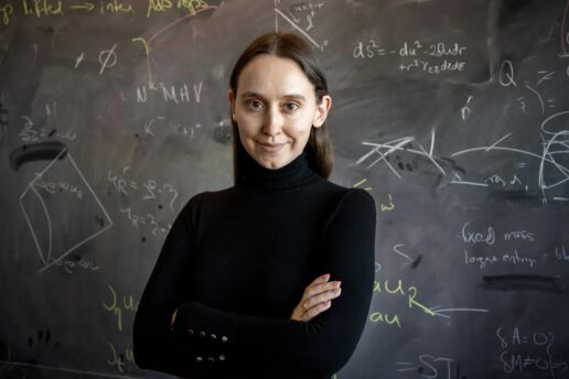 woman poses in front of blackboard