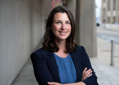 Woman smiles and poses with arms crossed