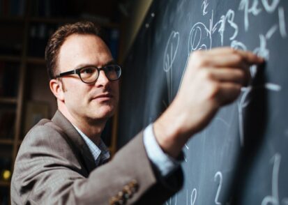 Jesse Thaler writes on a chalkboard