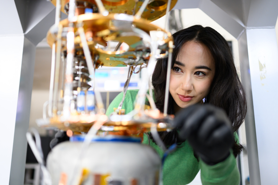 Close-up of person, Jessica Fry, tending an experiment in the lab, with only her face in focus