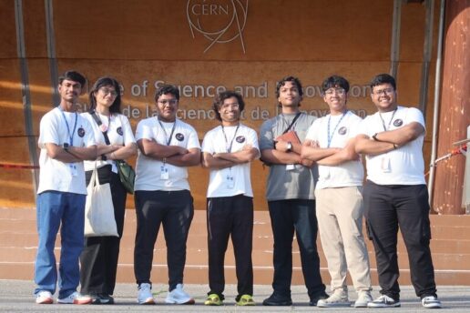 Manu Srivastava and 6 high school students pose standing in front of a sign at CERN with their arms folded