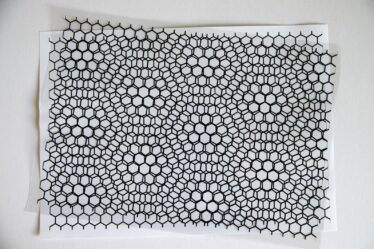 Two slightly rotated black hexagonal lattice sheets creating a moiré pattern over a white background.